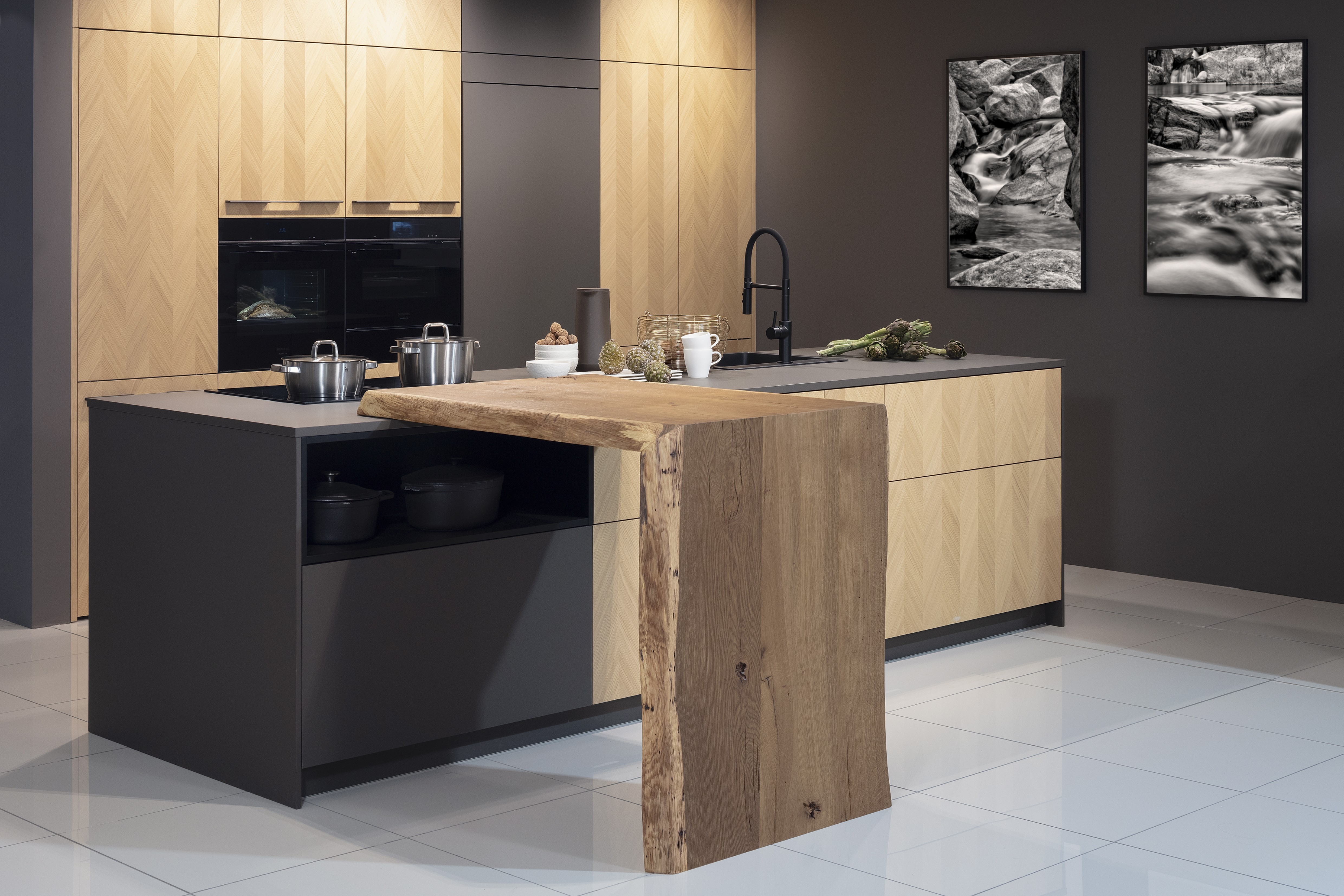 Front: Intarsia Gavi Eiche Furnier Resopal Brown Powder supermatt Korpus Schwarz APL: Resopal Brown Powder supermatt Geräte: Siemens Studio Line Spüle und Armatur: Blanco   Features: Front Echtholz Fischgrät-Optik, Kombination Echtholz und Resopal supermatt, Einbautür in Frontmaterial Resopal, Küchentheke Massivholz, APL = Korpusfarbe = Frontmaterial, Kombination Griffleiste und grifflos, Korpus in Frontmaterial, Wärmeschublade, Spüle und Armatur Schwarz, Besteckeinsatz. 